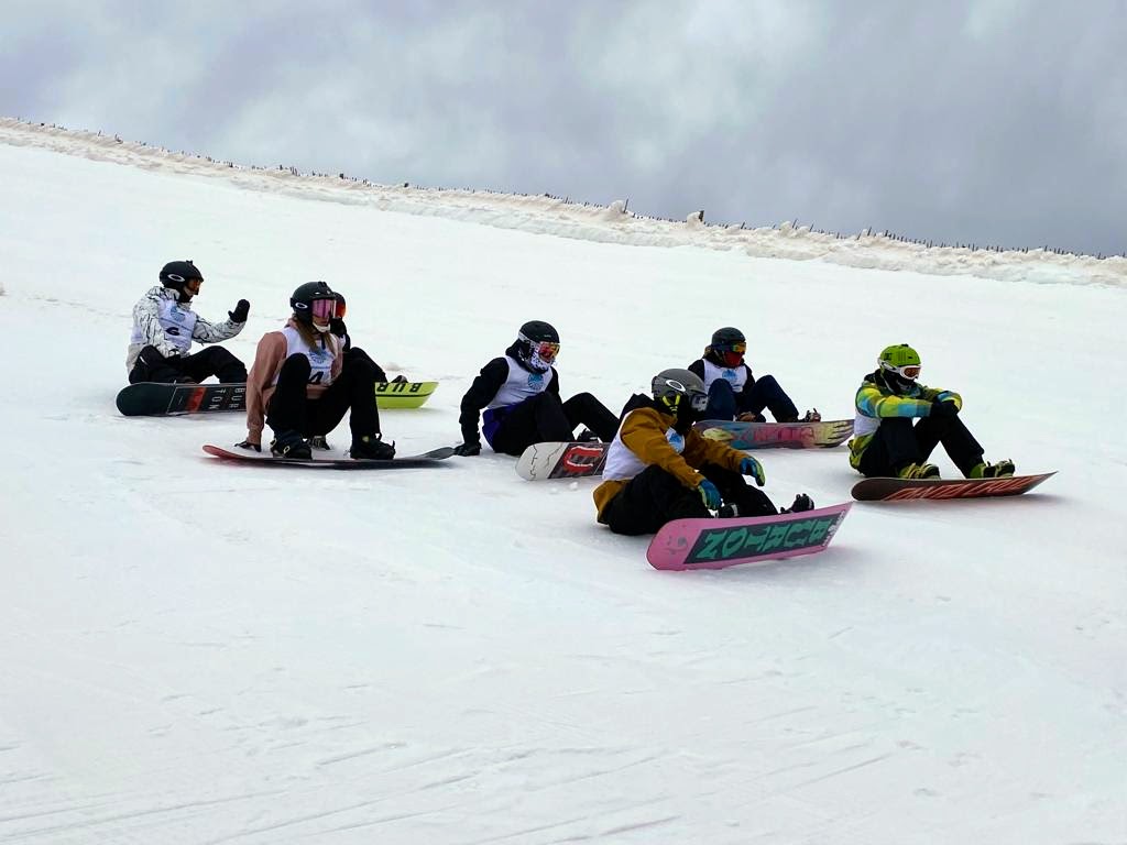 Alumnos de snowboard durante una sesión formativa en pista